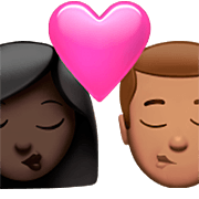 👩🏿‍❤️‍💋‍👨🏽 Emoji sich küssendes Paar - Frau: dunkle Hautfarbe, Mann: mittlere Hautfarbe Apple iOS 16.4.